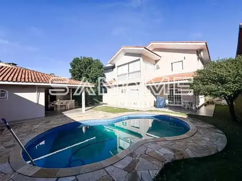 Área externa com piscina e casa ao fundo