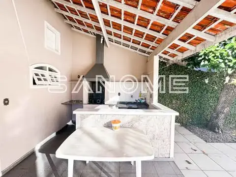 Área externa com churrasqueira e bancada de mármore