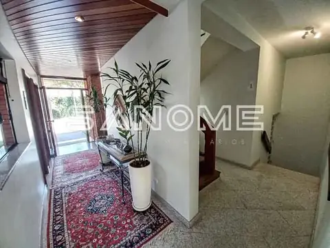 Corredor de entrada com plantas e porta de vidro