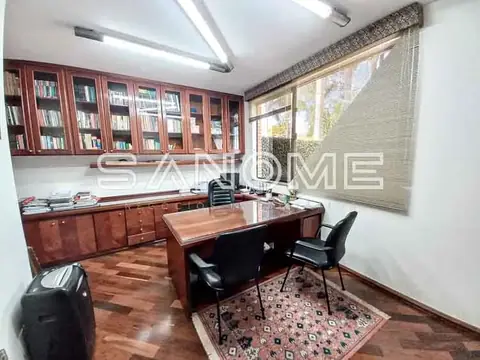 Escritório com mesa de trabalho e estantes de madeira