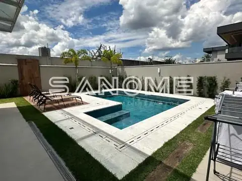 Área externa com piscina e espreguiçadeiras