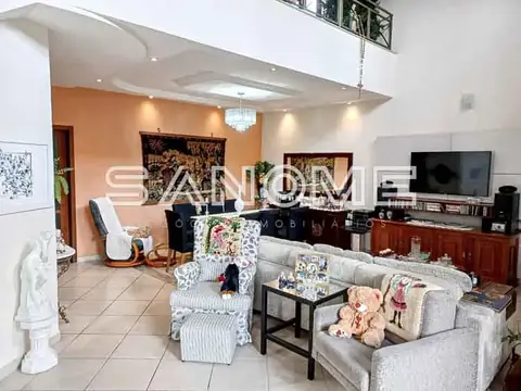 Sala de estar com sofá, parede laranja e TV