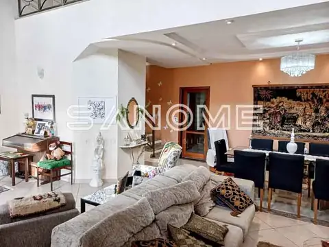 Sala de estar com sofá cinzento e parede laranja