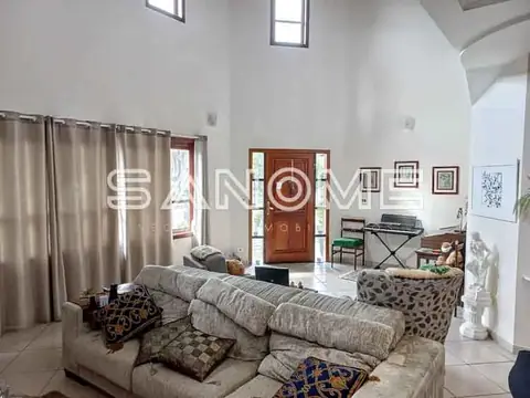 Sala de estar com sofá cinza e pé direito alto