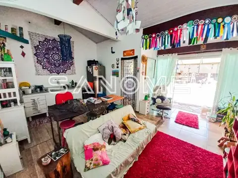 Quarto com cama, tapete rosa e janelas grandes