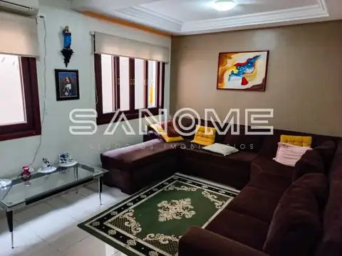 Sala de estar com sofá marrom e tapete verde
