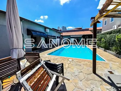 Área externa com piscina e espreguiçadeiras
