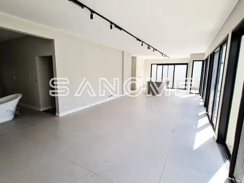 Sala ampla com piso claro e porta de vidro