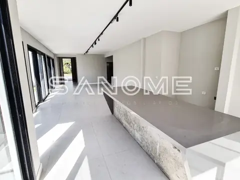 Sala ampla com piso em porcelanato e parede em tons claros