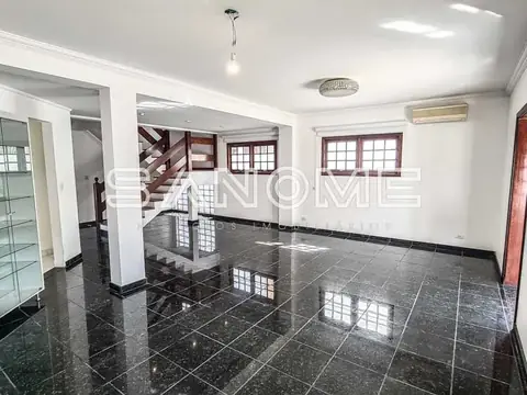 Sala ampla com piso de granito e escada de madeira