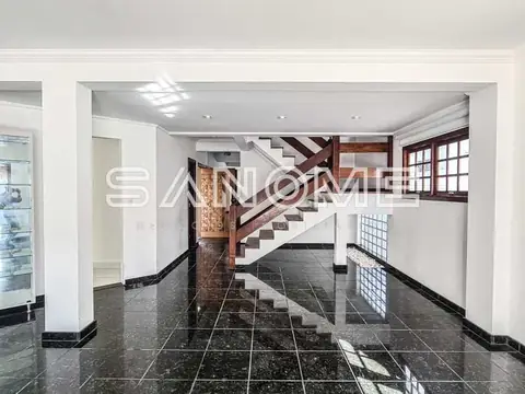 Entrada com escada em madeira e piso preto
