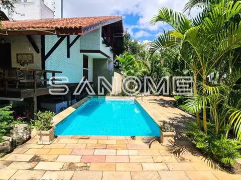 Área externa com piscina e casa ao fundo