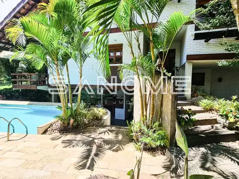 Área externa com piscina e palmeiras