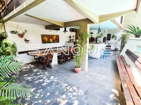 Varanda coberta com plantas e mesas de refeição