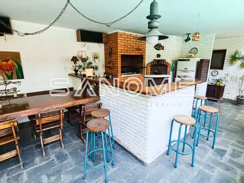 Cozinha aberta com bancada e bancos azuis