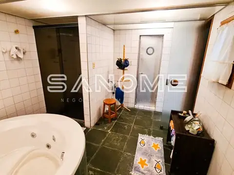 Banheiro com banheira, chuveiro e dois vasos sanitários