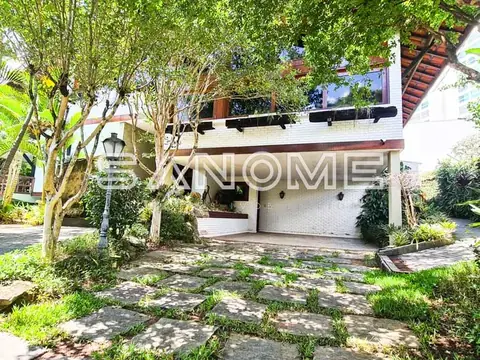 Fachada de casa com garagem e árvores