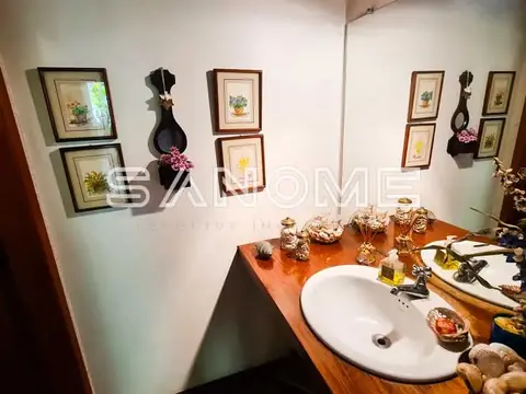 Banheiro com pia de porcelana e decoração na parede
