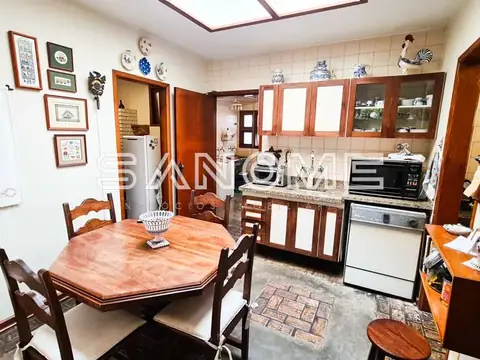 Cozinha com mesa de jantar e móveis em madeira