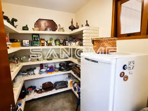 Cozinha com geladeira branca e prateleiras organizadas