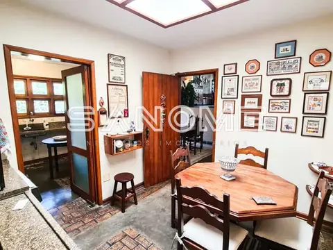 Sala de jantar com mesa de madeira e parede de quadros