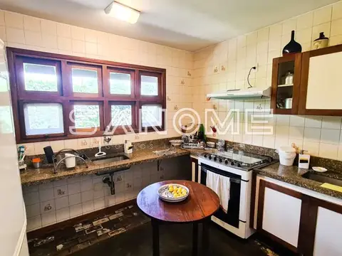 Cozinha com fogão, pia e mesa redonda de madeira
