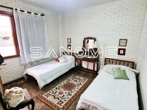 Quarto com duas camas de solteiro e parede de tijolos