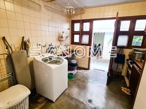 Lavanderia com máquina de lavar e piso cinzento