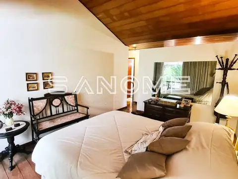 Quarto com cama de casal e banco decorativo