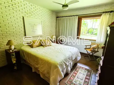 Quarto com cama de casal e parede de tijolos