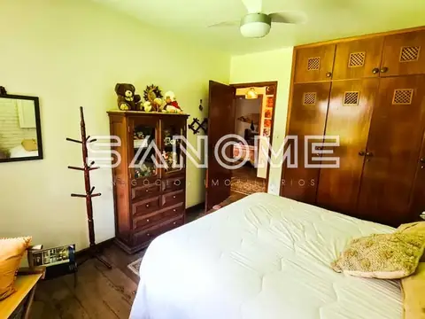 Quarto com cama de casal e guarda-roupa de madeira