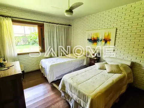 Quarto com duas camas e janela com vista para jardim