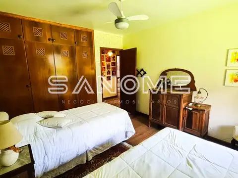 Quarto com duas camas e guarda-roupa em madeira