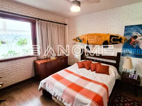 Quarto com cama de casal e prancha de surfe na parede