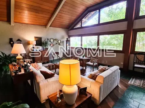 Sala de estar com pé-direito alto e grandes janelas