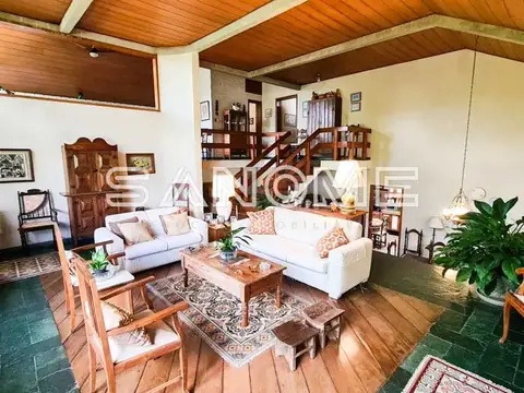 Sala de estar com sofás brancos e teto de madeira