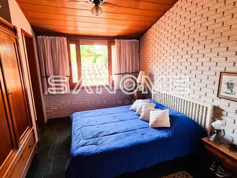 Quarto com cama de casal e parede de tijolos