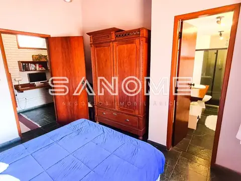 Quarto com cama, guarda-roupa e porta aberta para banheiro