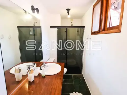 Banheiro com bancada em madeira e dois chuveiros