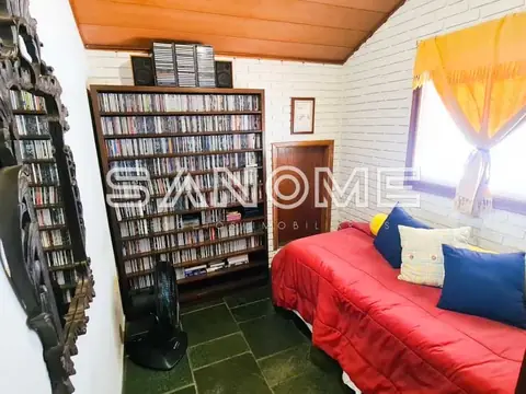 Quarto com cama, estantes de livros e janela