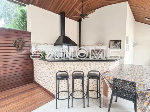 Área de churrasqueira com bancada e bancos altos