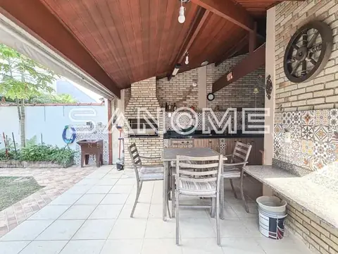 Área de lazer com mesa, cadeiras e churrasqueira