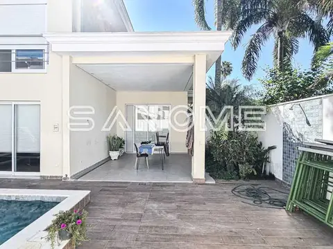 Área de lazer com cobertura e piscina ao fundo