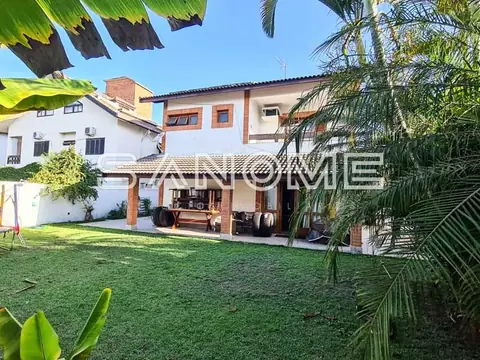 Casa com fachada laranja e branca, área externa com grama