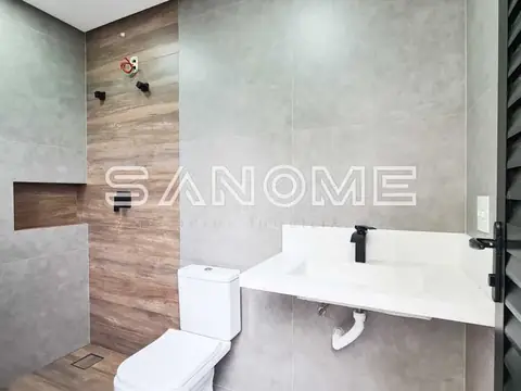 Banheiro com box, pia branca e azulejos cinza