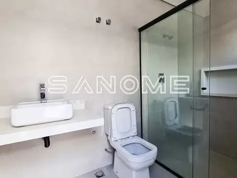 Banheiro com pia, vaso sanitário e box de vidro