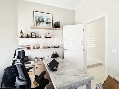 Escritório com mesa de mármore e prateleiras brancas
