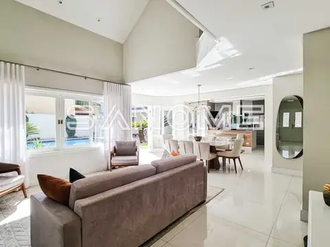 Sala de estar com sofá cinza e vista para área externa