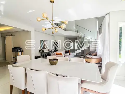 Sala de jantar com mesa redonda e cadeiras brancas