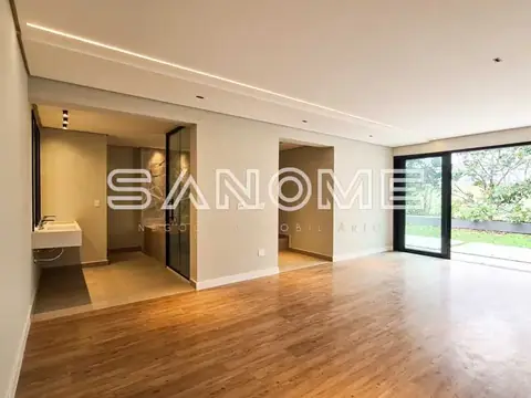 Sala ampla com piso de madeira e vista para área externa